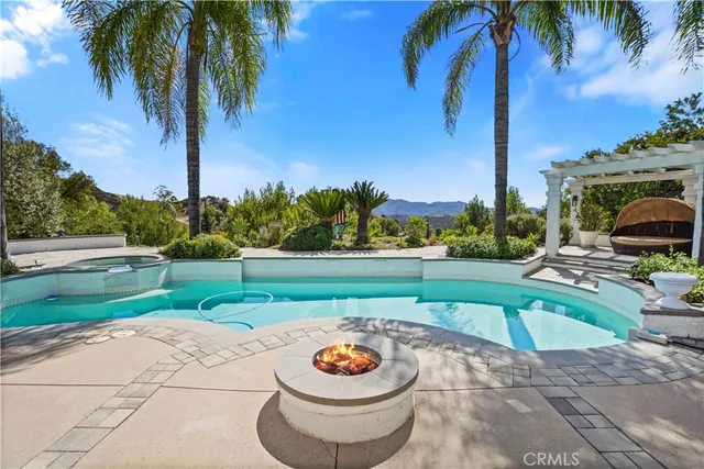 a patio with a table and chairs and a fire pit