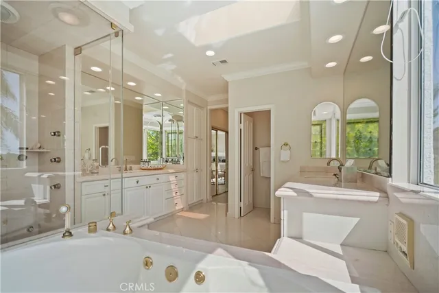 a bathroom with a double vanity sink mirror and bathtub