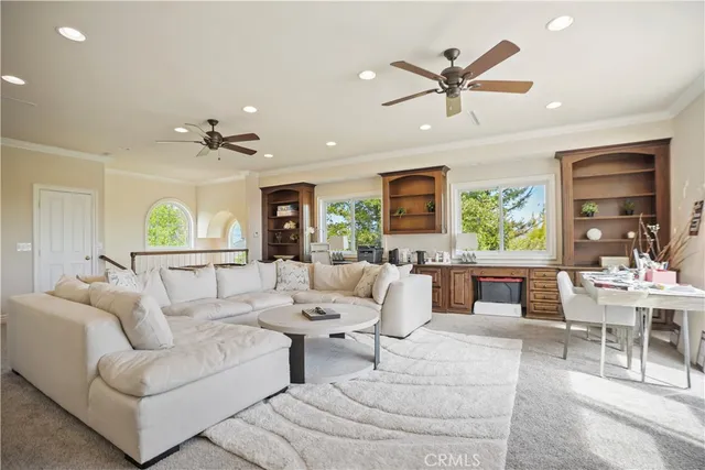 a living room with furniture ceiling fan and a window