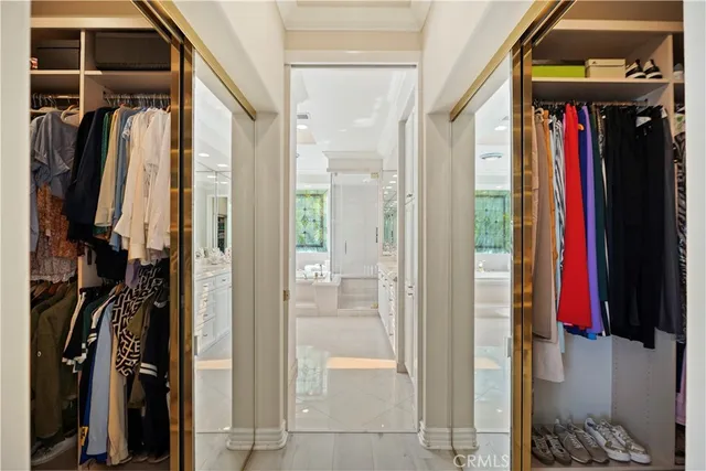 a view of walk in closet with clothes and shoes