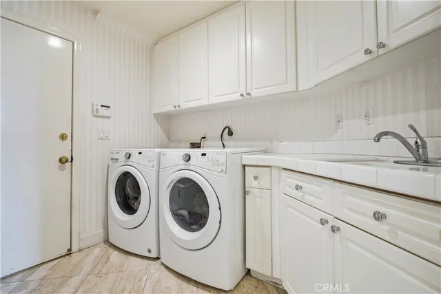 a utility room with sink dryer and washer