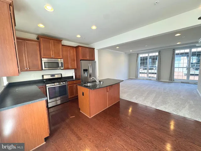 a kitchen with granite countertop a sink counter top space and cabinets