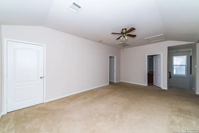 an empty room with closet and a ceiling fan