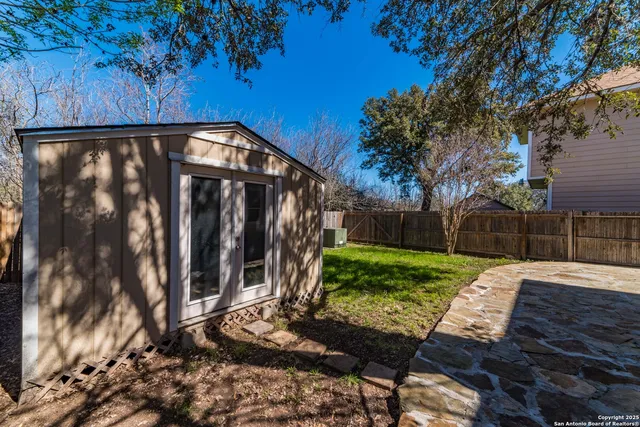 a view of a backyard with wooden fence