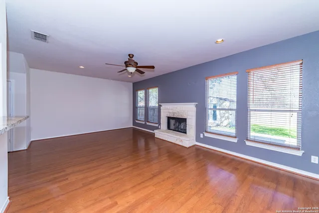 a view of an empty room with a fireplace and a window