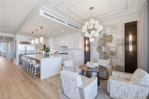 a room with stainless steel appliances a chandelier furniture and a chandelier