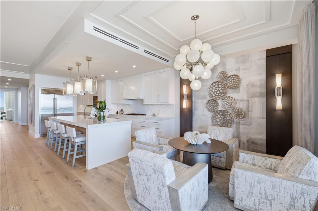 13945 Old Coast Road, Unit PH05 Naples, FL 34110 - Photo 11 of 37 a room with stainless steel appliances a chandelier furniture and a chandelier
