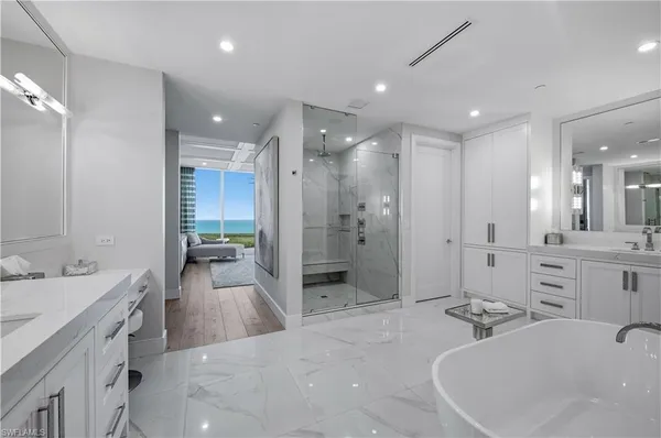 a bathroom with a bathtub shower sink double and mirror