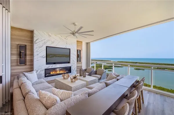 a living room with furniture a flat screen tv and a large window