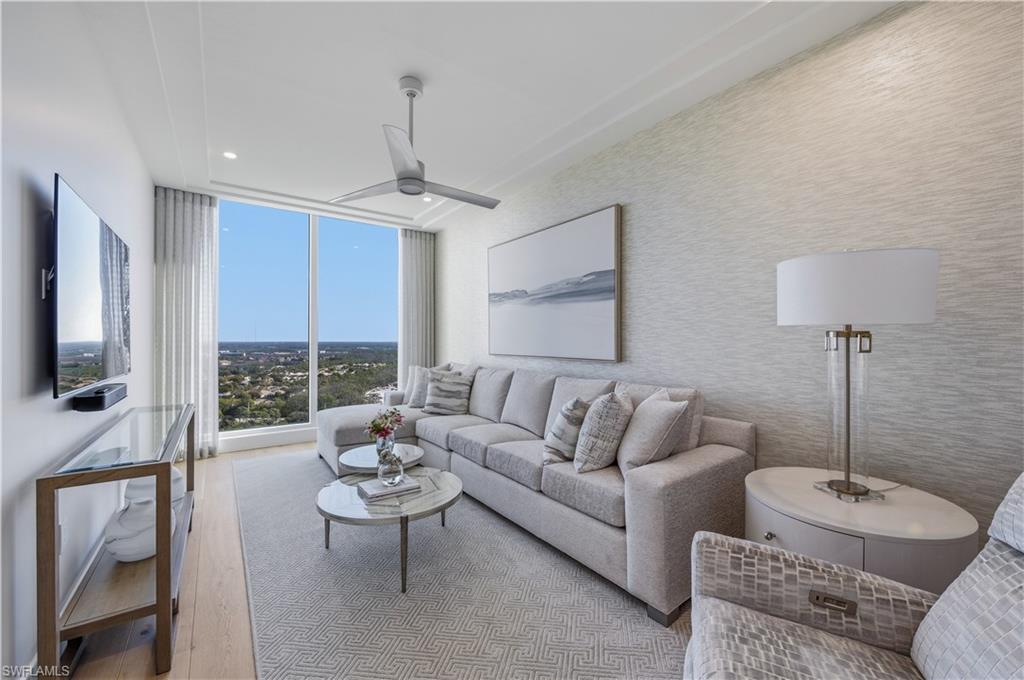 13945 Old Coast Road, Unit PH05 Naples, FL 34110 - Photo 24 of 37 a living room with furniture and a flat screen tv