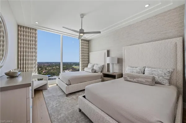 a spacious bedroom with two beds and large windows