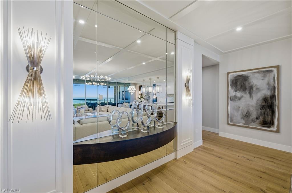13945 Old Coast Road, Unit PH05 Naples, FL 34110 - Photo 6 of 37 a view of living room and kitchen with wooden floor