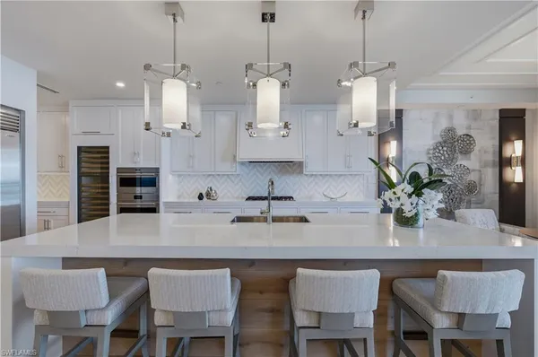 a kitchen with stainless steel appliances granite countertop a kitchen island a stove and a wooden cabinets