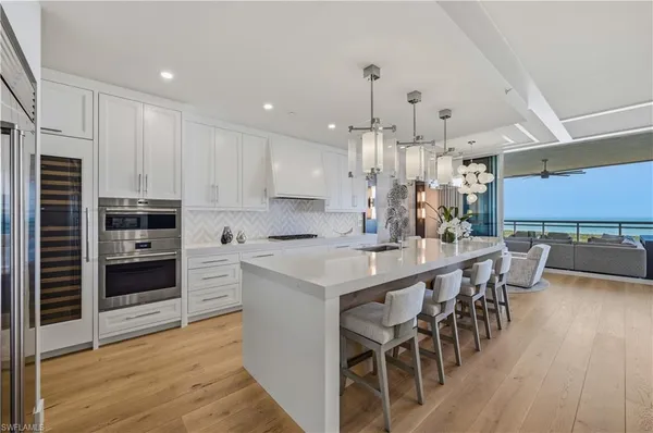 a kitchen with kitchen island granite countertop a table chairs microwave and cabinets