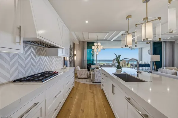 a kitchen with stainless steel appliances a sink a stove top oven a counter space and cabinets