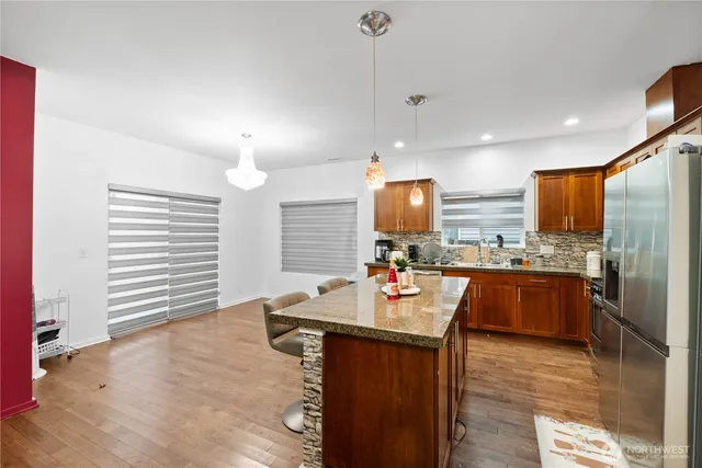 a kitchen with stainless steel appliances granite countertop a sink refrigerator and cabinets
