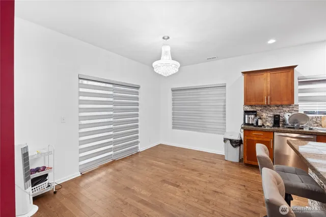 a view of a livingroom with furniture cabinet wooden floor and windows