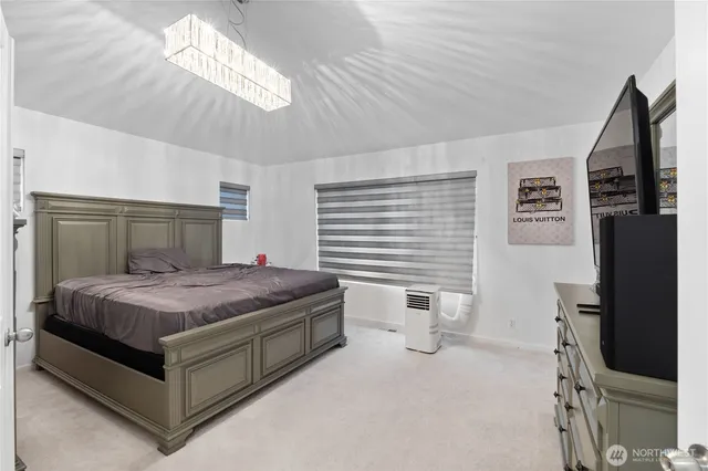 a bedroom with a bed and a chandelier