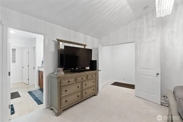 a room with a flat screen tv on dresser and a flat screen tv