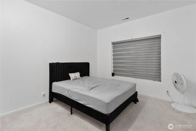 a large bed sitting in a bedroom next to a window