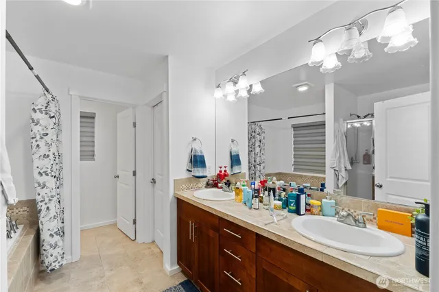 a spacious bathroom with a granite countertop sink a large mirror and a shower