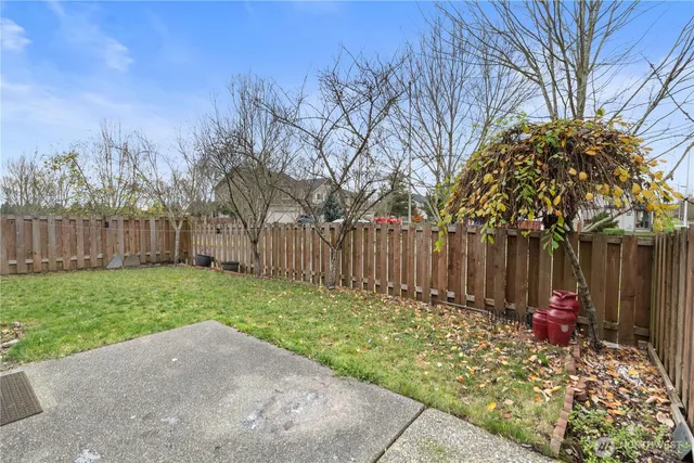 a view of a backyard with wooden fence
