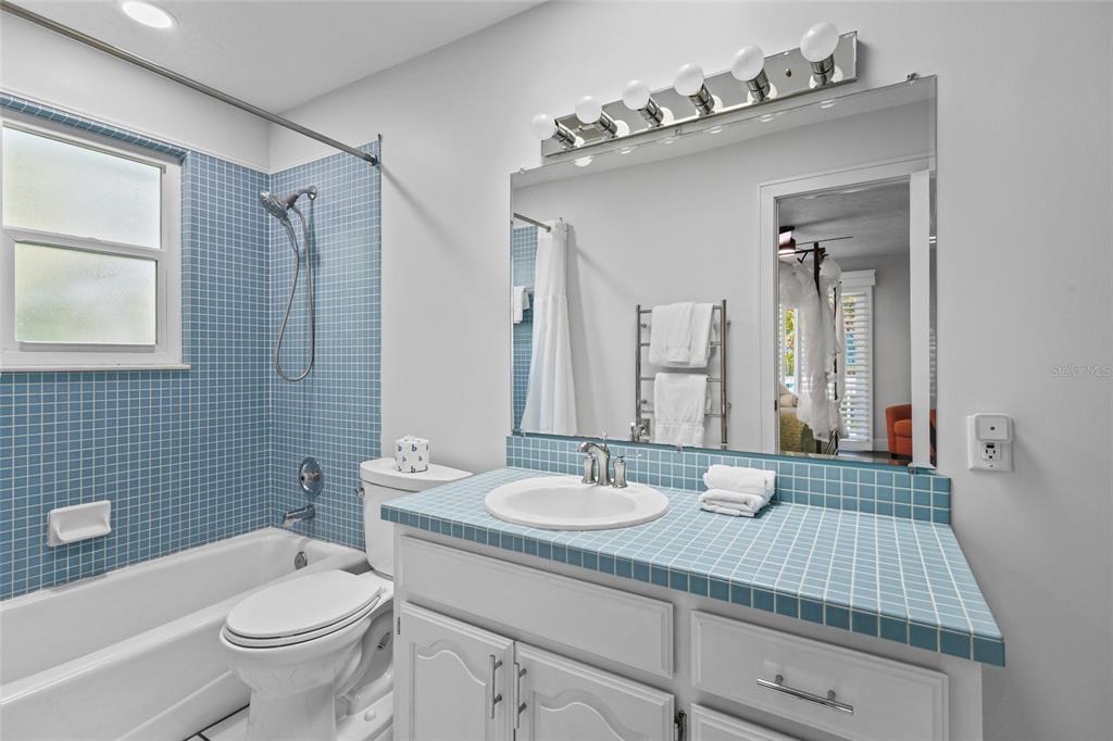 315 Spring Avenue Anna Maria, FL 34216 - Photo 35 of 63 a bathroom with a sink a toilet a mirror a vanity and shower
