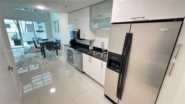 a kitchen with granite countertop a refrigerator a sink and a stove