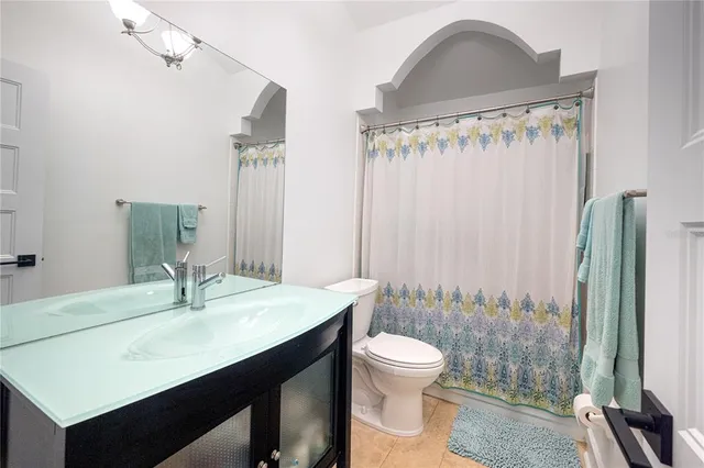 a bedroom with a bed a chandelier and a flat screen tv