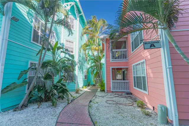 a view of a house with a small yard and potted plants