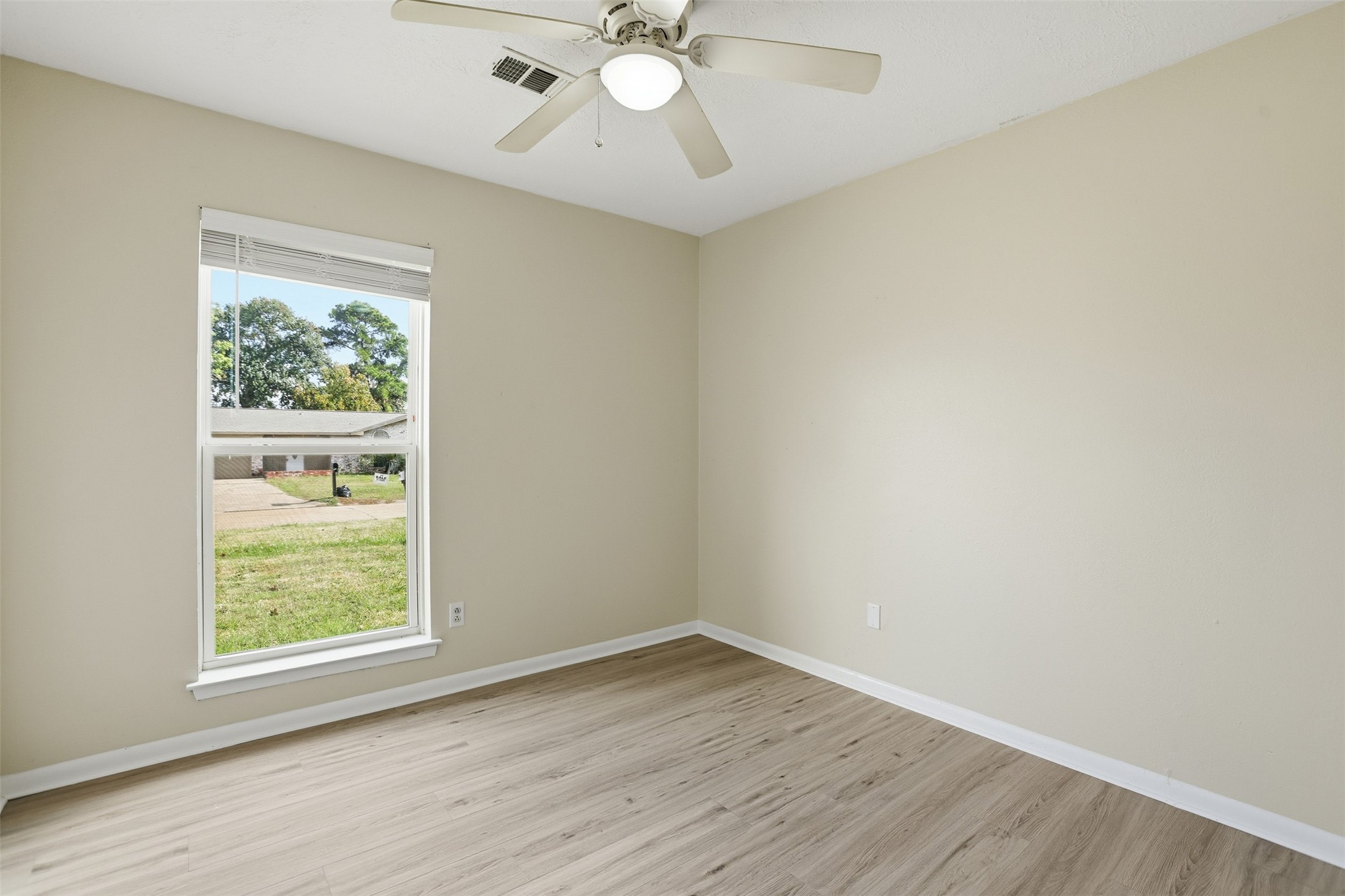 827 Parkhill Street Channelview, TX 77530 - Photo 13 of 26 an empty room with wooden floor fan and windows