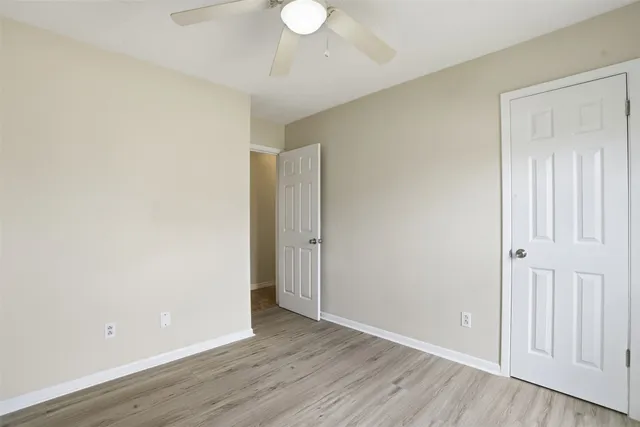a view of an empty room with wooden floor