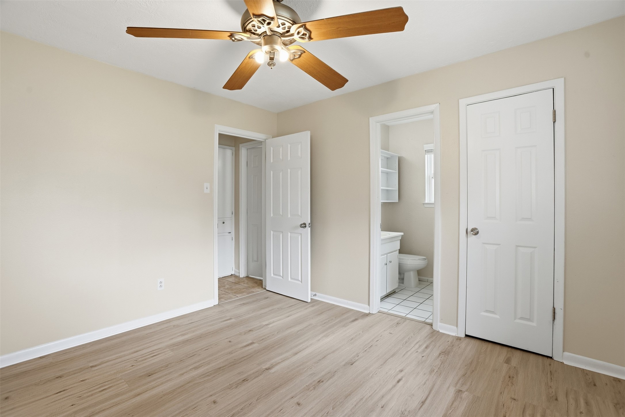827 Parkhill Street Channelview, TX 77530 - Photo 19 of 26 an empty room with wooden floor and a ceiling fan