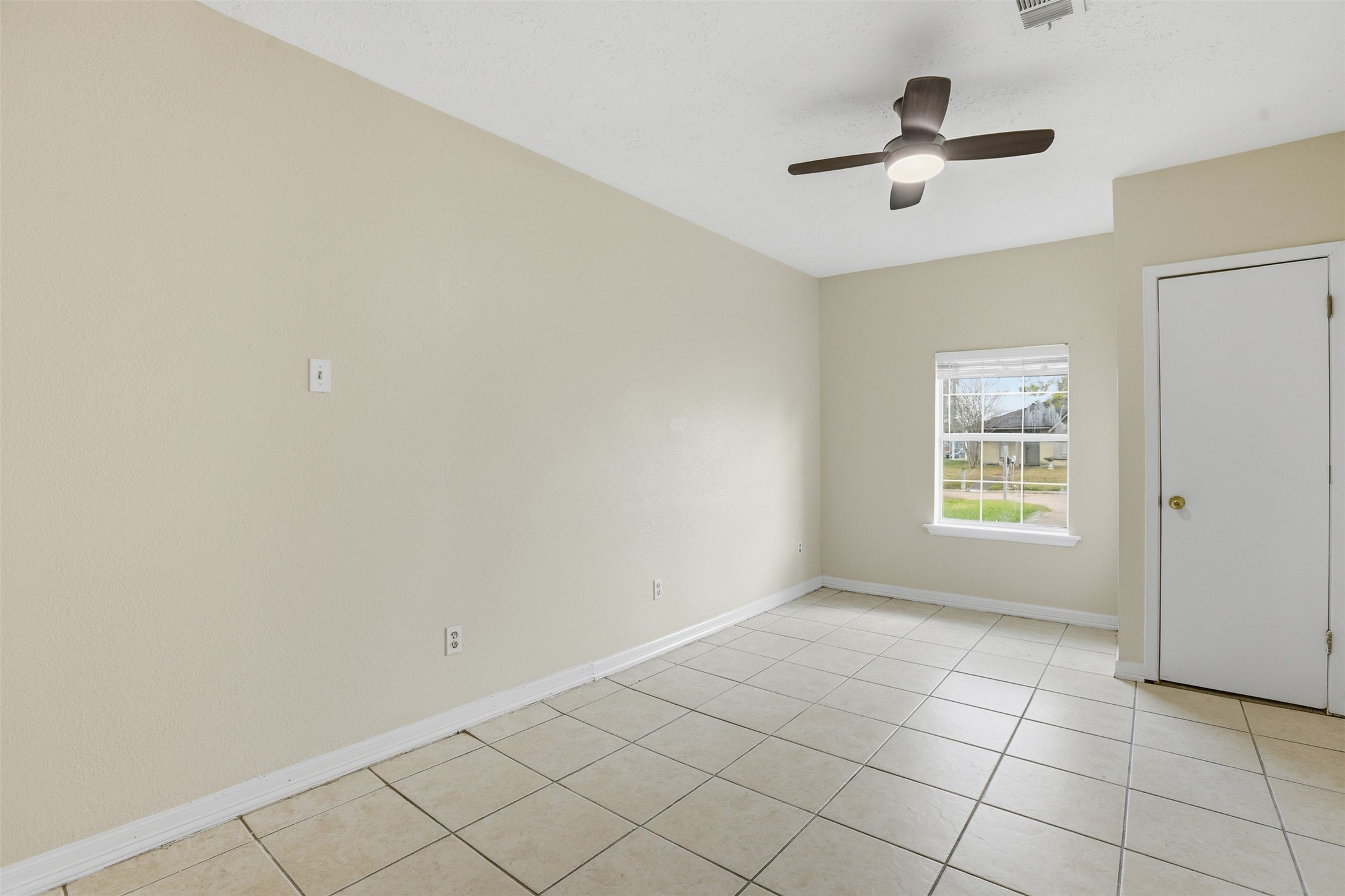 827 Parkhill Street Channelview, TX 77530 - Photo 23 of 26 an empty room with windows and fan