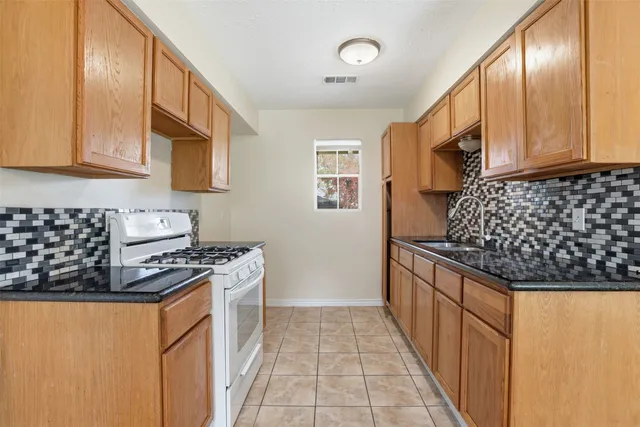 a kitchen with stainless steel appliances granite countertop a stove and a sink