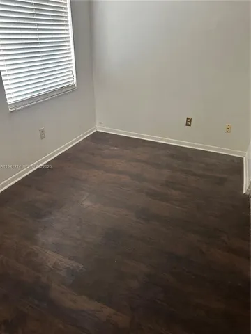 an empty room with wooden floor and a window