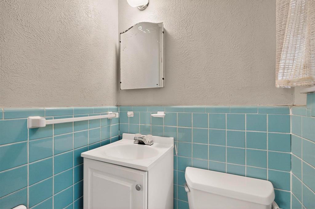 4508 Rutland Avenue Fort Worth, TX 76133 - Photo 18 of 36 a bathroom with a toilet a sink a mirror and vanity