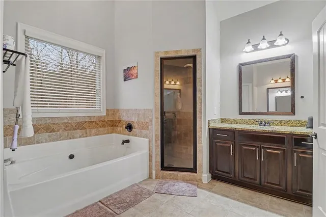 a bathroom with a tub a sink and a large mirror