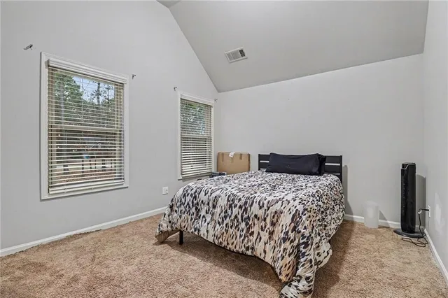 a bedroom with a bed and two windows