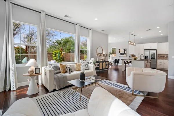 a living room with furniture large window and wooden floor