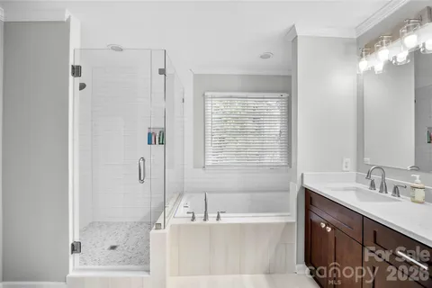 a bathroom with a tub sink shower and mirror