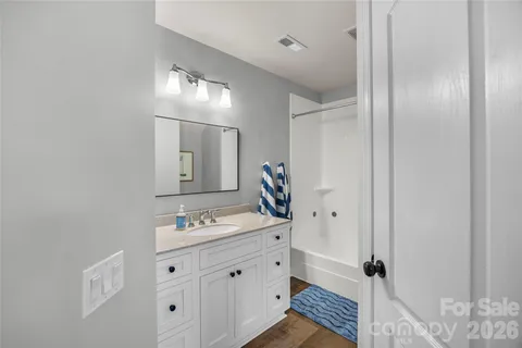 a bathroom with a double vanity sink and mirror with shower