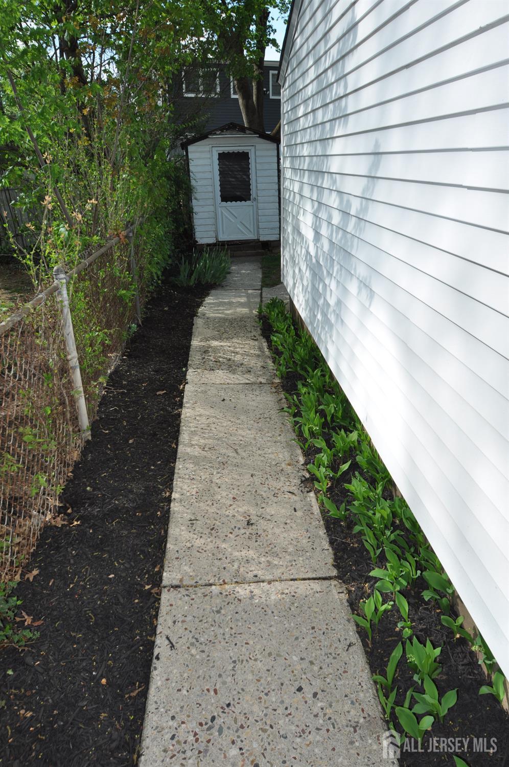 213 Old Post Road Edison, NJ 08817 - Photo 5 of 18 a pathway of a house with wooden fence