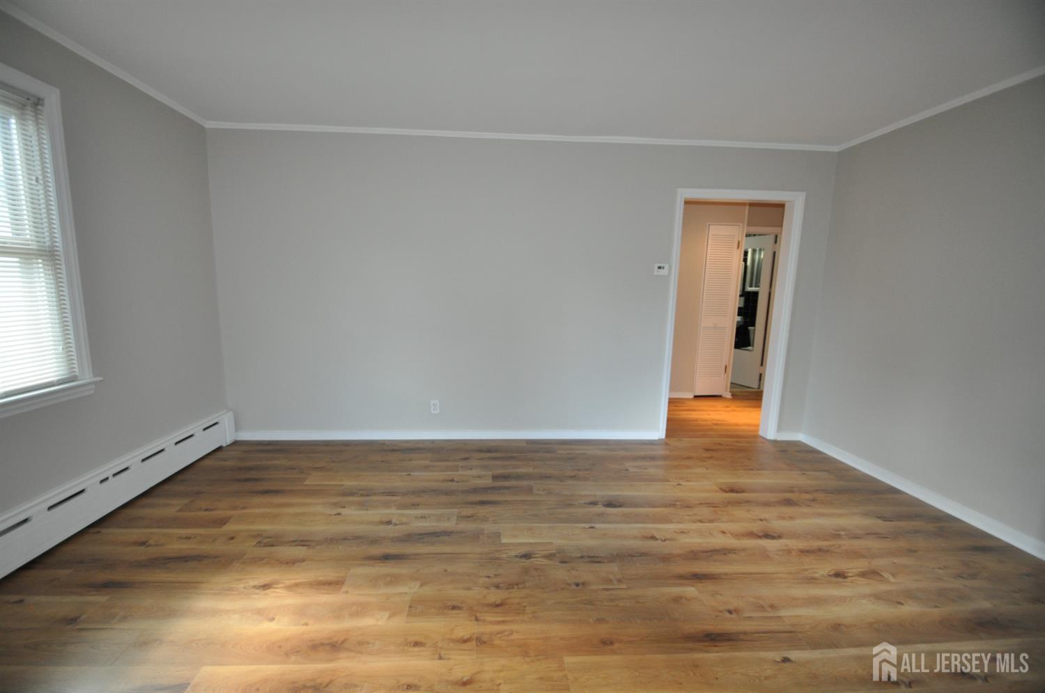 213 Old Post Road Edison, NJ 08817 - Photo 6 of 18 a view of an empty room with wooden floor and a window