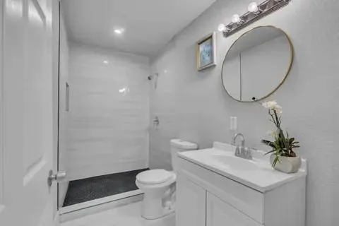 a bathroom with a sink a toilet and a mirror