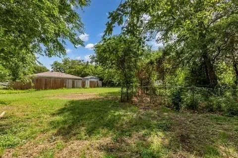 a view of a big yard with large trees