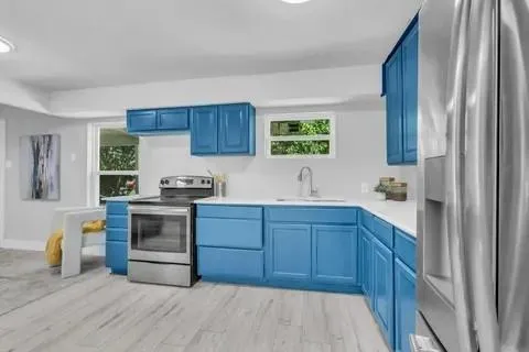 a kitchen with stainless steel appliances granite countertop a sink stove and refrigerator