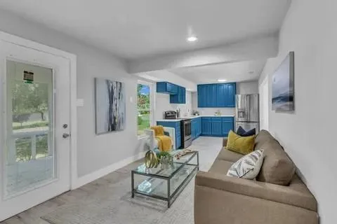 a living room with furniture and a view of kitchen