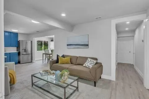 a living room with furniture and kitchen view