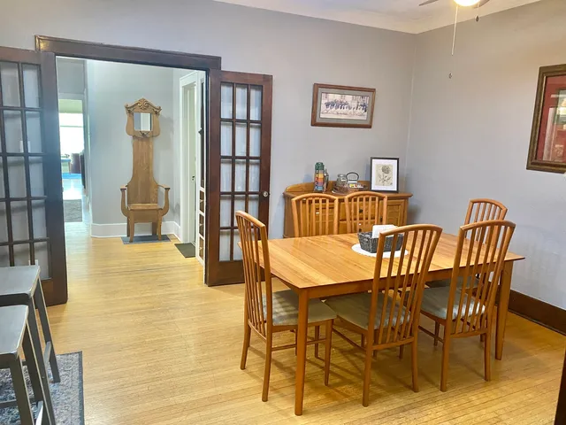 a view of a dining room with furniture a rug and wooden floor